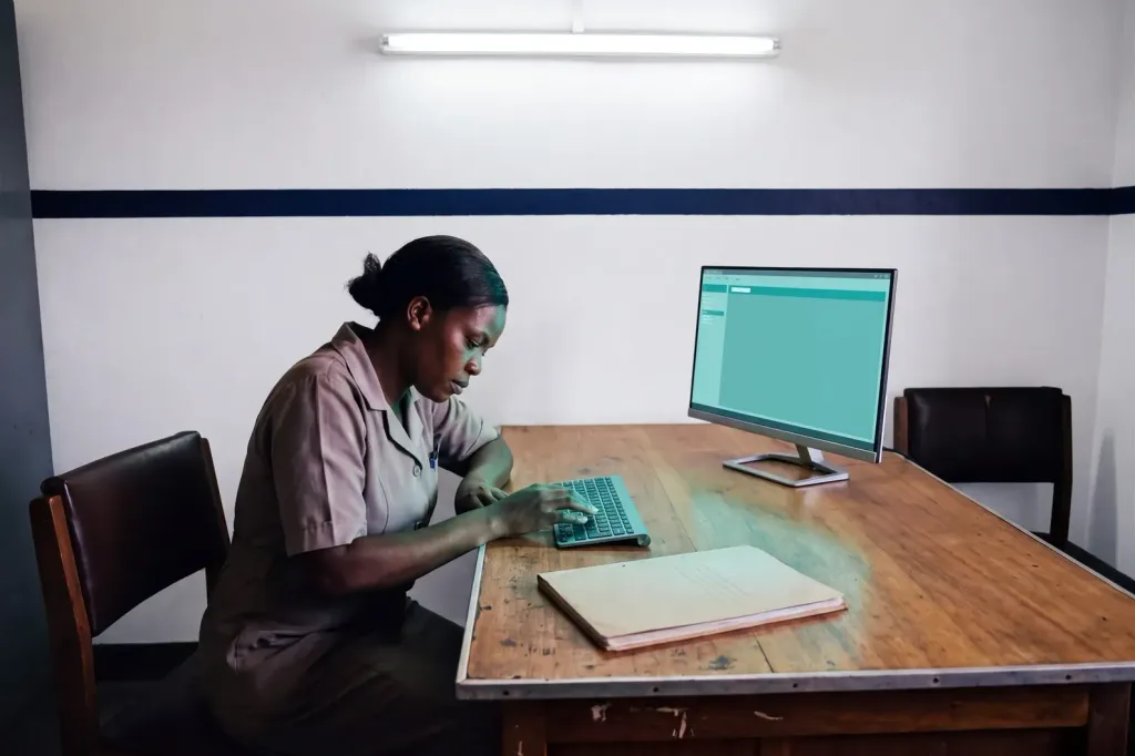 The same clerk working at a modern screen and keyboard.